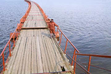 Image showing fisherman in brown raincoat