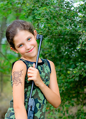 Image showing Girl with gun in wood