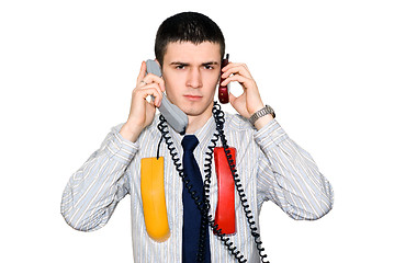 Image showing The young man speaks by two phone