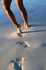 Image showing Woman legs on sand with footprints