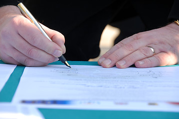 Image showing Businessman is signing a contract