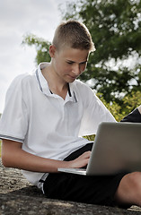 Image showing Young man using laptop in a park