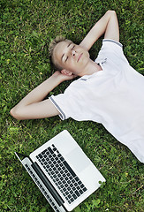 Image showing Boy lying on grass with a laptop