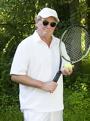 Image showing middle age senior tennis player male demonstating stroke