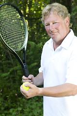 Image showing  middle age senior tennis player male demonstating stroke