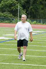 Image showing middle age man exercising on sports field