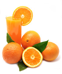 Image showing Oranges with green leaves and glass of juice on a white backgrou