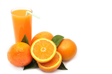 Image showing Oranges with green leaves and glass of juice on a white backgrou