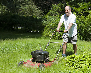 Image showing man cutting grass at suburban house