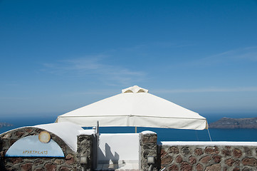 Image showing stone tile patio with volcanic island view on santorini