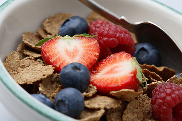 Image showing Bowl of breakfast cereal with fruit and a spoon.