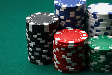 Image showing Stacks of poker chips on a green surface.