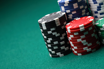 Image showing Stacks of poker chips on a green surface.