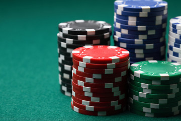 Image showing Stacks of poker chips on a green surface.