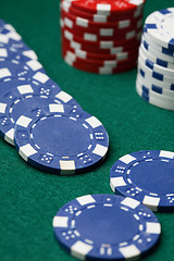 Image showing Poker chips spread out over a green surface.