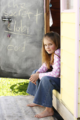 Image showing Pretty young girl sitting at her playhouse.