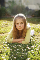 Image showing A pretty young girl lying on the grass amongst flowers.