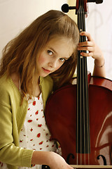 Image showing Close-up portrait of a pretty young girl with a cello.