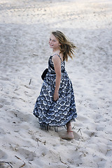 Image showing Pretty teenager walking on the beach.