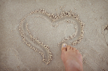 Image showing Drawing a heart shape in the sand.