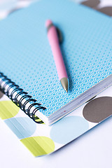 Image showing Brightly colored notebook, folder and pen.