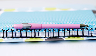 Image showing Brightly colored notebook, folder and pen.