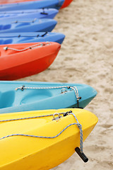 Image showing Colorful kayaks on the sand.