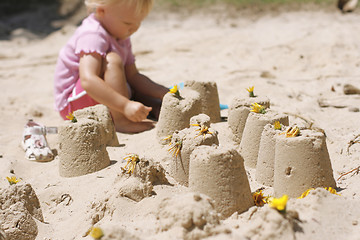 Image showing A little girl making sand castles. 