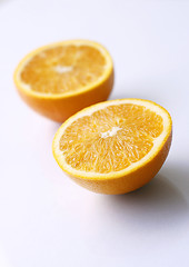 Image showing Two orange halves on a light surface.