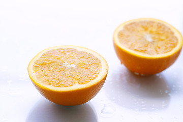 Image showing Two orange halves on a light surface.