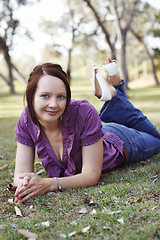 Image showing Portrait of a beautiful woman lying on the grass.