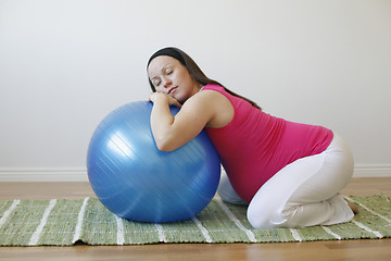 Image showing Young pregnant woman doing a relaxation exercise with fitness ba