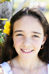 Image showing Close-up portrait of a pretty, dark haired young girl outdoors.