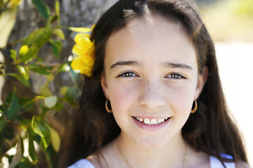 Image showing Close-up portrait of a pretty, dark haired young girl outdoors.