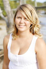 Image showing Portrait of a happy beautiful young blonde woman at the beach.