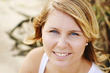 Image showing Portrait of a happy beautiful young blonde woman at the beach.