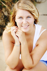 Image showing Portrait of a happy beautiful young blonde woman at the beach.