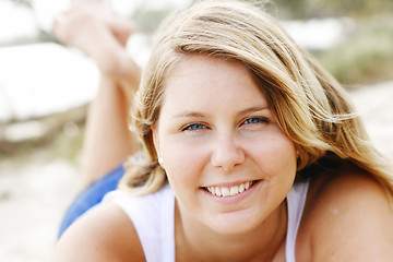 Image showing Portrait of a happy beautiful young blonde woman at the beach.