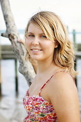 Image showing Portrait of a happy beautiful young blonde woman at the beach.