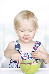 Image showing Cute little girl and her breakfast porridge bowl.