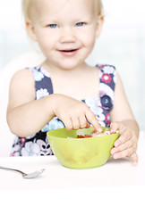 Image showing Cute little girl and her breakfast porridge bowl.