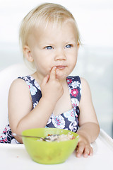 Image showing Cute little girl and her breakfast porridge bowl.