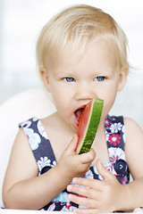 Image showing Cute little girl eating a watermelon.