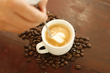 Image showing Barista creating a heart shaped coffee art design.