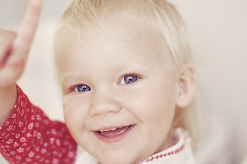 Image showing Portrait of a smiling and laughing toddler pointing.