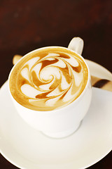 Image showing Delicious latte with coffee art swirl design.