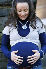 Image showing Happy young pregnant woman outdoors.