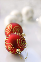 Image showing Red and silver colored Christmas baubles on a glass table.