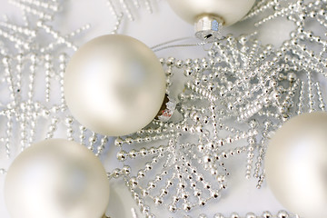 Image showing Silver colored Christmas baubles on glass table.