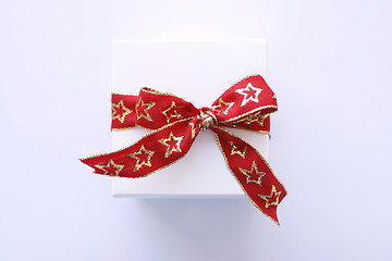 Image showing Christmas gift in white wrapping and red ribbon.